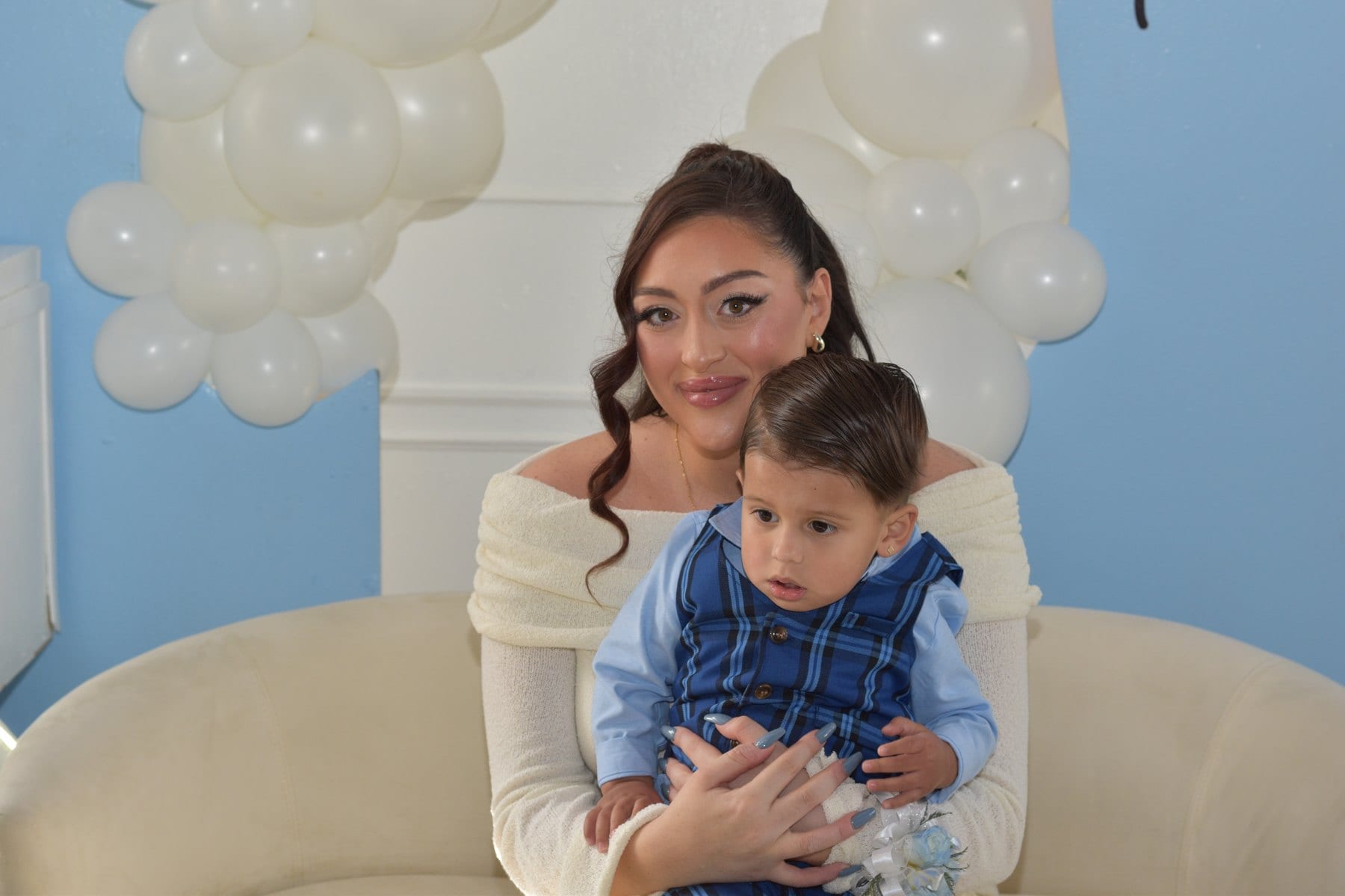 Family portrait beside a balloon display at a private celebration